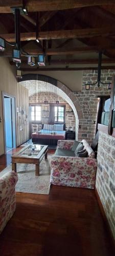 a living room with two couches and a brick wall at Soul boutique hotel in Monodendri