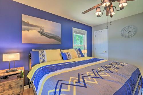 a blue bedroom with a bed and a clock on the wall at Lakefront Eatonton Getaway with Dock and Grill! in Resseaus Crossroads