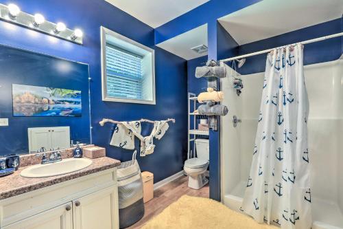 a blue bathroom with a sink and a shower at Lakefront Eatonton Getaway with Dock and Grill! in Resseaus Crossroads