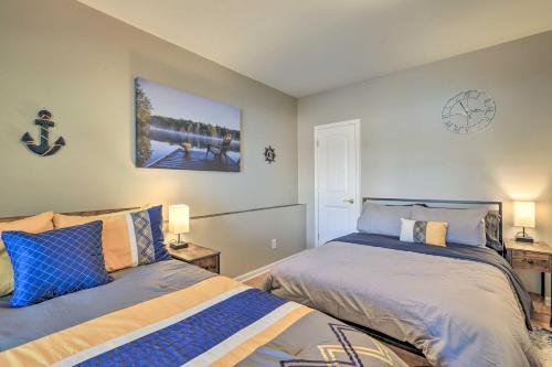 a bedroom with two beds and a clock on the wall at Lakefront Eatonton Getaway with Dock and Grill! in Resseaus Crossroads