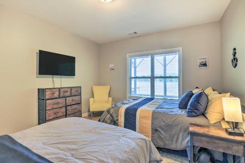 a bedroom with a bed and a tv and a chair at Lakefront Eatonton Getaway with Dock and Grill! in Resseaus Crossroads