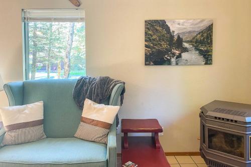 a living room with a blue couch and a stove at Beautiful McCall Cabin Perfect for Families! in McCall