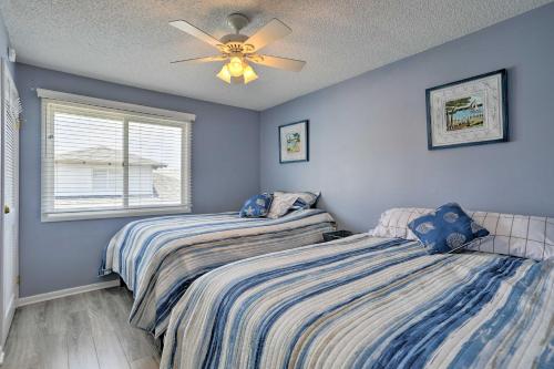 two beds in a bedroom with blue walls and a ceiling fan at Quaint Wildwood Condo about Walk to Beach! in Wildwood