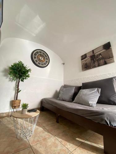 a living room with a couch and a clock on the wall at Évora Romana Alojamentos T2 Aqueduto in Évora