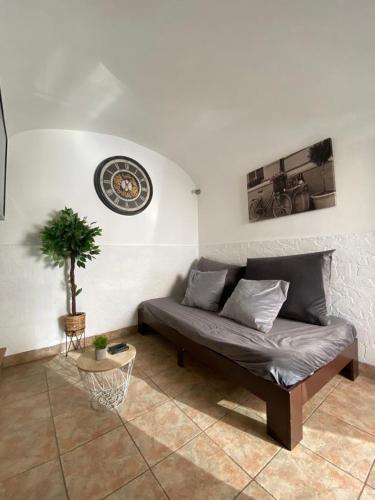 a living room with a couch and a clock on the wall at Évora Romana Alojamentos T2 Aqueduto in Évora