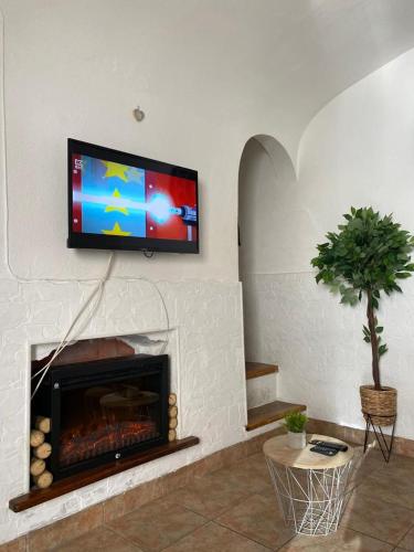 a living room with a fireplace with a television above it at Évora Romana Alojamentos T2 Aqueduto in Évora