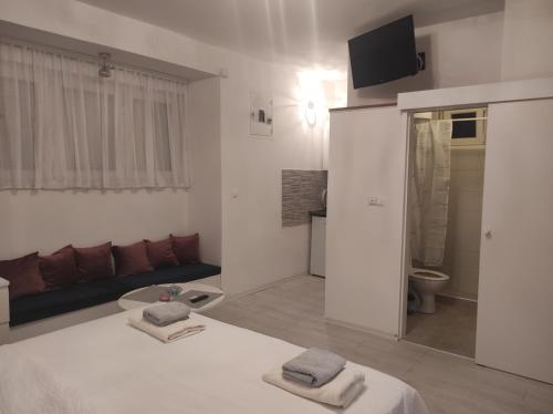 a white room with a bed and a couch at Apartments Golden Bridge in Mostar