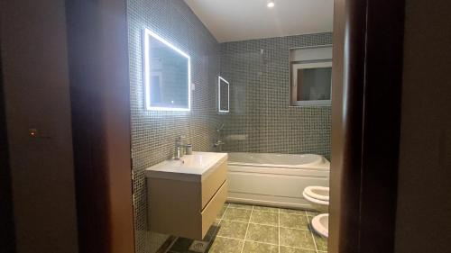 y baño con lavabo, bañera y aseo. en Parenzo Premium Apartment, en Poreč