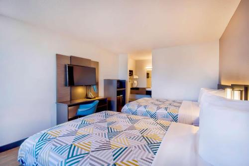 a hotel room with two beds and a flat screen tv at Motel 6-Vallejo, CA - Six Flags West in Vallejo