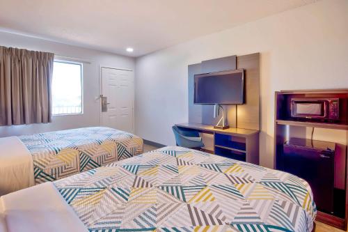 a hotel room with two beds and a flat screen tv at Motel 6-Vallejo, CA - Six Flags West in Vallejo