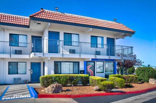 a apartment building with a balcony and bushes at Motel 6-Vallejo, CA - Six Flags West in Vallejo