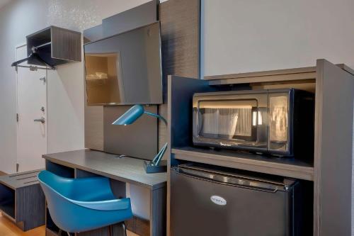 cocina con microondas y silla azul en Motel 6-Denison, TX, en Denison