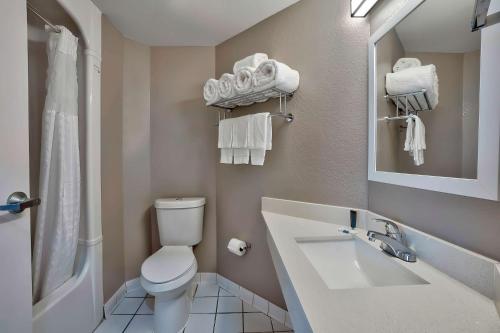 a bathroom with a white toilet and a sink at Motel 6-Denison, TX in Denison