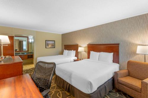 a hotel room with two beds and a chair at Best Western Plus Burley Inn & Convention Center in Burley