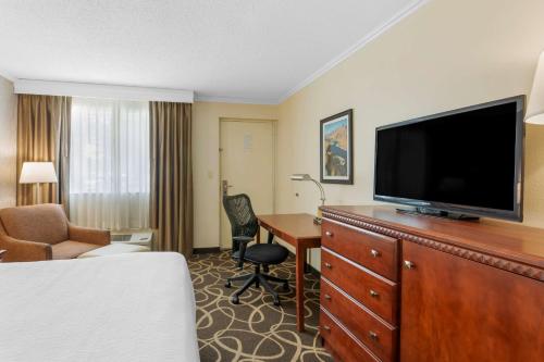 a hotel room with a bed and a television and a desk at Best Western Plus Burley Inn & Convention Center in Burley