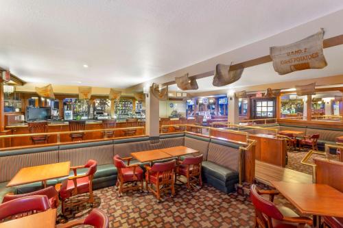 a restaurant with tables and chairs and a bar at Best Western Plus Burley Inn & Convention Center in Burley