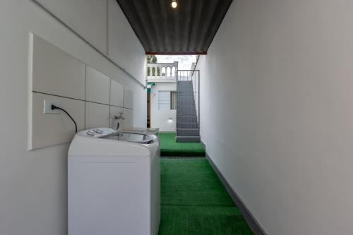 a hallway with a washing machine and green carpet at Casa no Tatuapé com 3 Dormitórios e Garagem in Sao Paulo