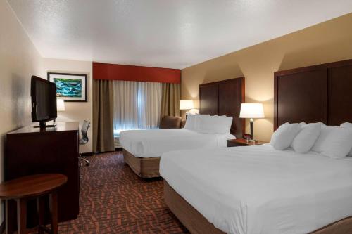 a hotel room with two beds and a flat screen tv at Best Western Pony Soldier in Portland