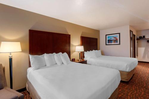 a hotel room with two white beds and a chair at Best Western Pony Soldier in Portland