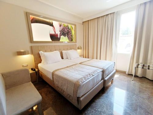 a hotel room with a large bed and a chair at Best Western Premier Milano Palace Hotel in Modena