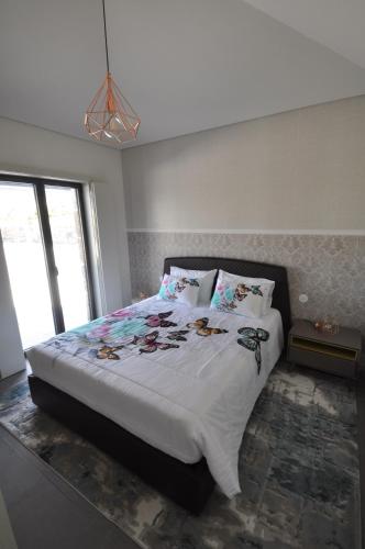 um quarto com uma cama grande com lençóis brancos e almofadas em Olival da Seara em Marco de Canavezes
