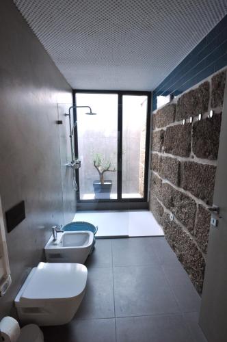 a bathroom with two toilets and a sink and a window at Olival da Seara in Marco de Canaveses