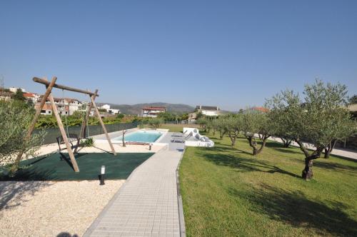 einen Garten mit einer Schaukel und einem Spielplatz in der Unterkunft Olival da Seara in Marco de Canavezes