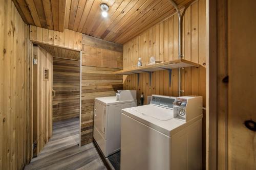 a laundry room with a washer and dryer and wooden walls at Stoke Hotel SureStay Collection by Best Western in Revelstoke