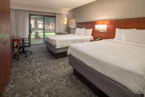 a hotel room with two beds and a desk at Sonesta Select Seattle Bellevue Redmond in Bellevue