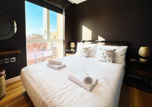 - une chambre avec un grand lit blanc et des serviettes dans l'établissement The Aviator's Attic - Luxury City Centre Retreat, à York