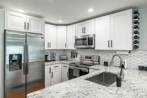a kitchen with white cabinets and a stainless steel refrigerator at Grand Oaks Terminal in the Heights in Tampa