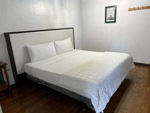 a bed with white sheets and pillows in a room at Hacienda Juanita in Maricao