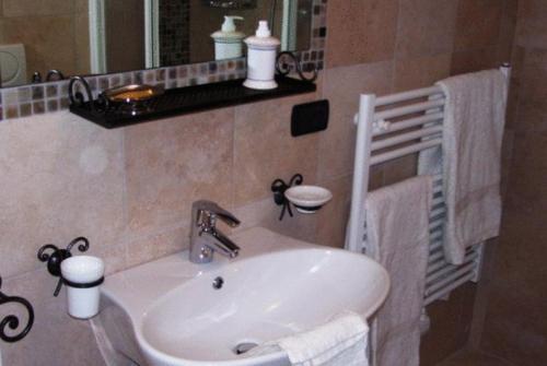 a bathroom with a sink and a mirror and towels at Virtus Et Otium - Feldererhof in Vipiteno