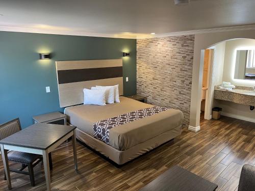 une chambre d'hôtel avec un lit et une table dans l'établissement Walnut Inn & Suites West Covina, à West Covina