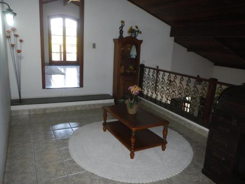 a living room with a coffee table and a clock at Chácara Tâmo na mió, Confortável casa de campo para famílias com Wifi, max 15 pessoas in Limeira