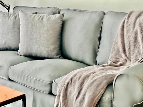 a grey couch with a blanket on it at Canaryislandshost l Las Olas in Costa Teguise