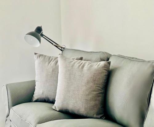a green couch with two pillows and a lamp at Canaryislandshost l Las Olas in Costa Teguise