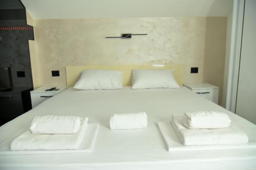 a large white bed with two white pillows on it at Pansion Eden in Niš