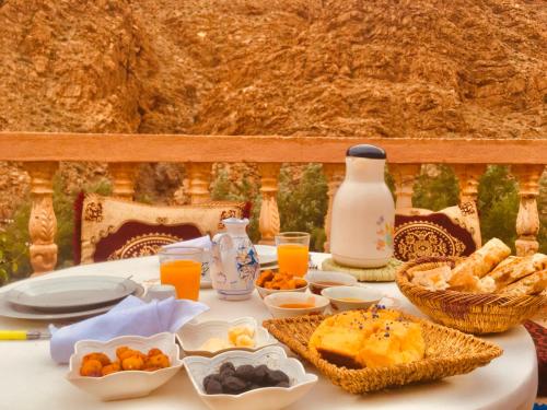 a table with breakfast foods and drinks on it at Hôtel panoramique de la vallée in Aït Idaïr