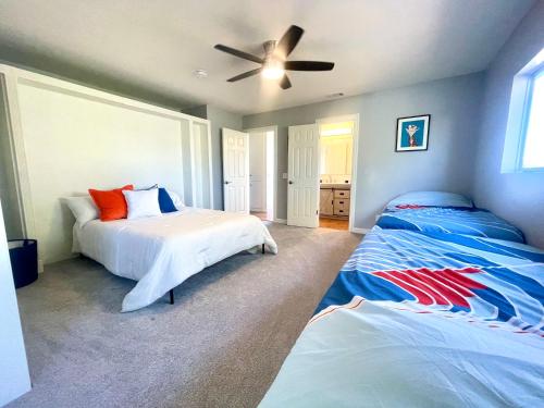 1 dormitorio con 2 camas y ventilador de techo en Lovely Beach Home - 2 min walk to the beach - Game Room - Channel Islands!, en Oxnard