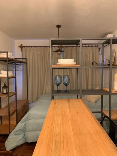 una habitación con una mesa y estanterías con copas de vino en Comodo monoambiente bien ubicado en Cordon en Montevideo