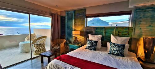 a bedroom with a bed and a large window at African Groove Camps Bay in Cape Town
