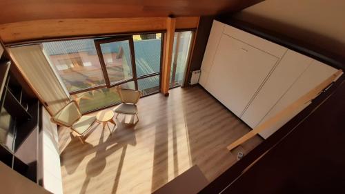una vista aérea de una habitación con sillas y ventanas en Monoambiente de diseño único, muy cálido y bien ubicado. 18V2 en San Martín de los Andes