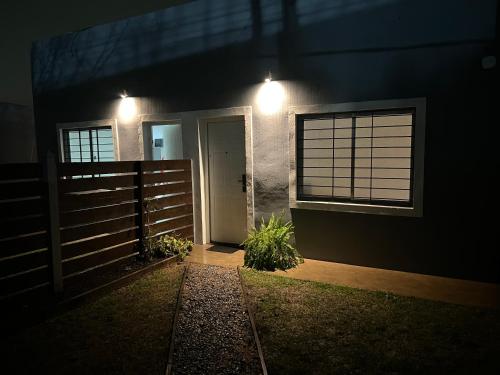 パイサンドゥーにあるApart Del Este 1の塀と夜間の扉のある家