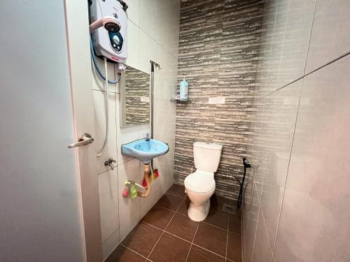 a small bathroom with a toilet and a sink at Jiaxin Homestay - Puteri Wangsa 家馨民宿 in Ulu Tiram
