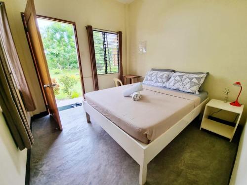 um quarto com uma cama e uma grande janela em Bahandi Beach Lodge em Mambajao