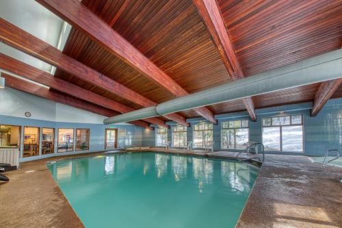 an indoor swimming pool with a wooden ceiling at Rustic Relaxation in Winter Park in Winter Park