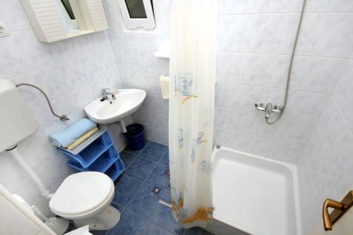 a white bathroom with a toilet and a sink at Apartment Supetarska Draga - Gornja 2016c in Supetarska Draga