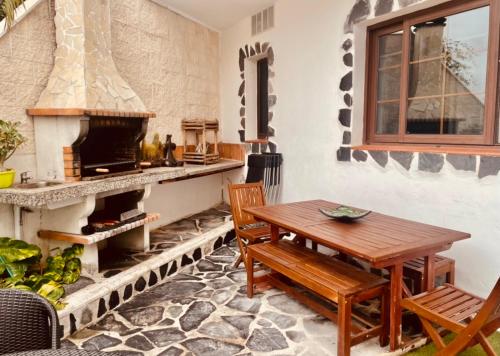 cocina con mesa de madera y chimenea en Pintadera´s house/Tara, en Icod de los Vinos