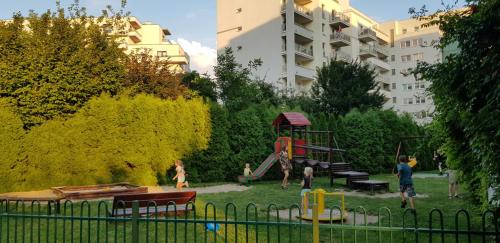 華沙的住宿－Apartament z balkonem Przy parku，儿童游乐场和儿童在公园玩耍